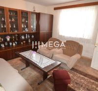 Living room in a family house with a display cabinet, armchairs, and a table with lace.