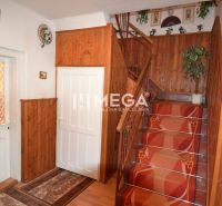 A staircase in a family house with wooden paneling and a red carpet.