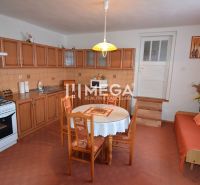 A kitchen in a family house with wooden cabinets and a dining table.