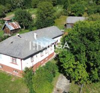 A family house in Vyšné Ladičkovce surrounded by greenery, with a yard and a wooden annex.