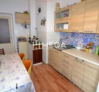 A kitchen in a family house with a wooden decor floor and colorful tiles.