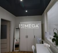A bedroom with a dark ceiling, a white wardrobe, and a mirror in a three-room apartment.