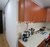 A kitchen with brown cabinets and appliances in a 3-room apartment, floor with wood decor.