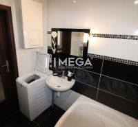 Bathroom with a sink, washing machine, and bathtub in a 3-room apartment.