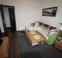 Living room with wood-patterned flooring and a sofa in a three-room apartment.