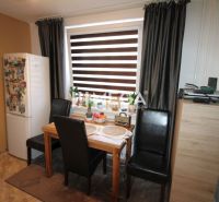 Dining room in a 3-room apartment with a dining table, black chairs, and a refrigerator.