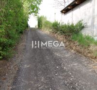 Access path through greenery to residential plots on Brestovska Street in Humenne.