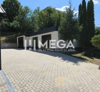 A courtyard with a staircase, garages, and trees near a 4-room apartment in Jasenov.