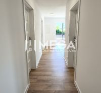 Hallway in a 4-room apartment, wooden decor flooring, light walls, entrance to the balcony.