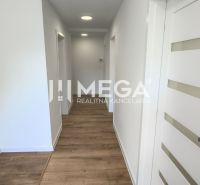 A hallway in a 4-room apartment with white walls and a floor with a wood decor.