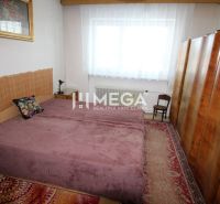 Bedroom in a family house with carpet, built-in wardrobe, and a painting above the bed.