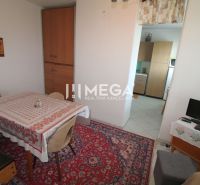 Dining room in a family house with a carpet, table, and kitchenette.