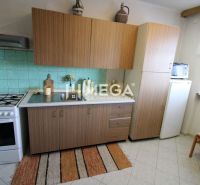 A kitchen with a counter, stove, and sink in a family house.