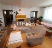 Living room in a family house with sofas, a table, and a fireplace, with a wooden decor floor.