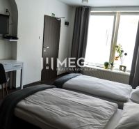 A hotel room with two beds, a television, and a floor with a wooden decor.