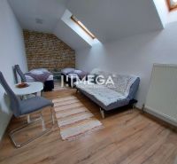 Attic room with two beds, a sofa, and a wooden decor floor in hotels and guesthouses.