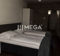 A room with two beds, a table, and a floor with a wooden decor. Hotels and guesthouses.