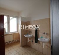 Bathroom in offices with two sinks and a window, butter-cream tiles.