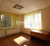 Bright office with vertical blinds and wood-patterned flooring.