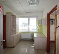 An office interior with modern furniture and a window, offering a bright workspace.