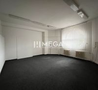 Office space with carpet flooring, a large window, and vertical blinds.