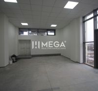 Commercial space with concrete flooring, large windows, and white walls.