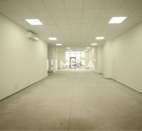 Interior of a commercial space with white walls and textured flooring without decor.