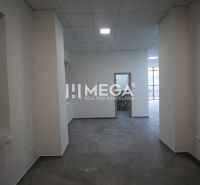 Interior of commercial spaces with tiles and a window, neutral colors, well-lit rooms.