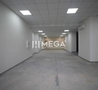 A large empty commercial space with white walls and tiled flooring.