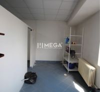 Interior of commercial premises with a blue floor, shelf, and radiator.