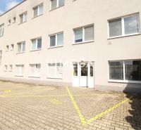 Commercial premises on Tolstého Street in Humenné with parking spaces and a white facade.