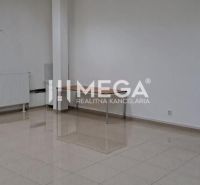 Spacious offices with white walls and tiles, a dining table, a radiator by the window.