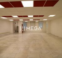Spacious commercial spaces with tiled floors and a bright ceiling with red panels.