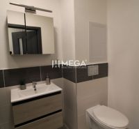 Bathroom in a 2-room apartment with tiles, a cabinet, and a mirror above the sink.