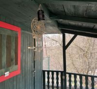 Garden in ZO Poniklec, Humenné, with a wooden terrace and a dreamcatcher.