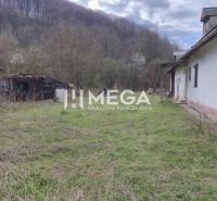 A family house in Čabiny with adjacent farm buildings on a plot surrounded by nature.