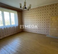 A family house with a wooden decor floor, patterned wallpaper, and a large window.