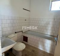 Bathroom with shower and toilet in a family house, basic interior with white tiles.