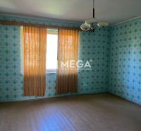 A room in a family house with patterned wallpaper and a wooden decor floor.