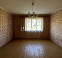 A room with wallpaper and wooden decor flooring in a family house.