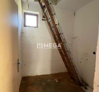 A ladder leads to the attic in a family house with a wooden decor floor.