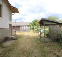 A garden by a family house in the village of Zbudská Belá, with a shelter and a wooden structure.