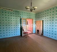 A room with wallpaper in a family house with a wooden decor floor and tiles.