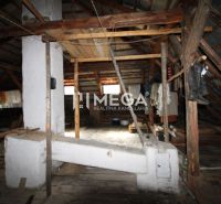The attic of a family house with wooden beams and storage items.