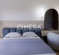 Bedroom in a family house with a comfortable bed, table and mirror, floor with wooden decor.