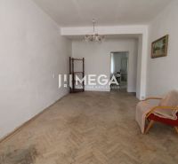 Living room with an old armchair and a floor with a wooden decor in a 2-room apartment.
