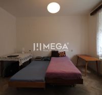 Bedroom in a 2-room apartment with a bed, a table, and a floor with a wooden decor.