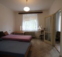 Bedroom with two beds and a wooden decor floor in a two-room apartment.