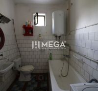 A bathroom in a family house with a bathtub, a sink, and a boiler on the wall.