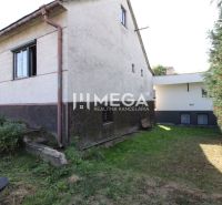 A family house on Volica Street in the town of Volica with a grassy yard and shrubs.